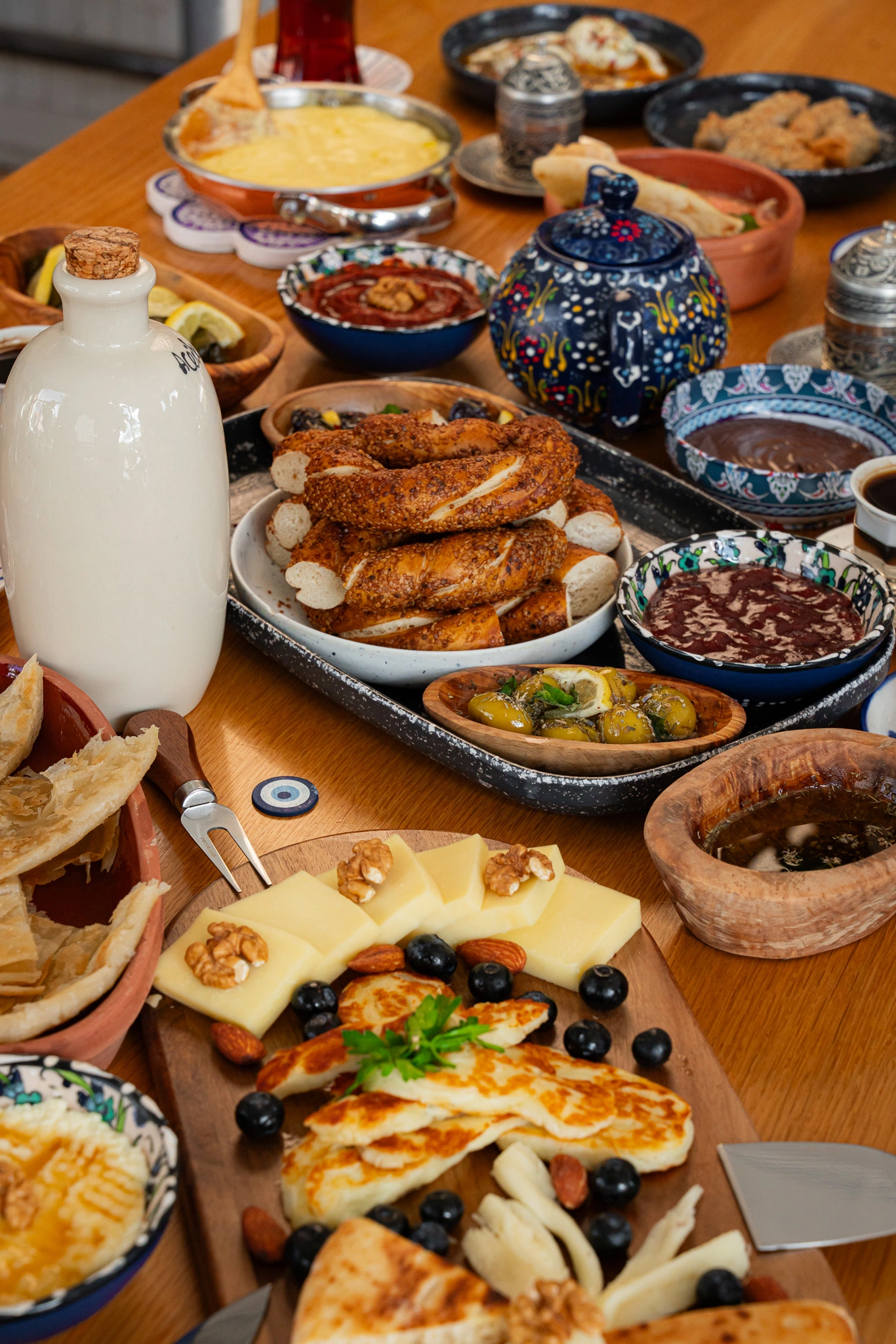 Close-up of a Turkish breakfast spread at The Jesse Reno, with simit, bal-kaymak, Aegean olives, cheese, and gozleme on a wooden table.